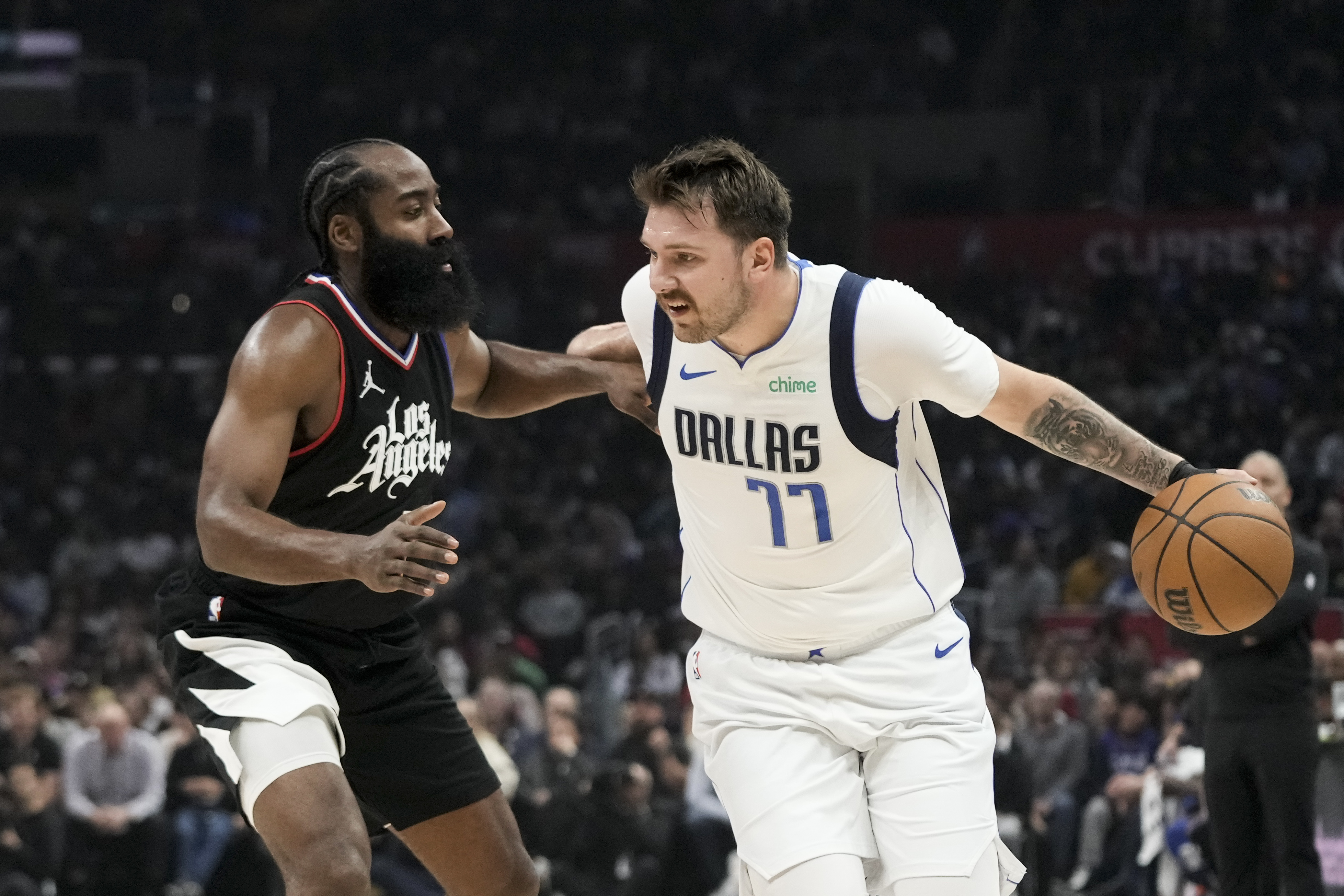 Los Angeles Clippers' James Harden, left, pressures Dallas Mavericks' Luka Doncic during the first half of an NBA basketball game Saturday, Nov. 25, 2023, in Los Angeles. (AP Photo/Jae C. Hong)